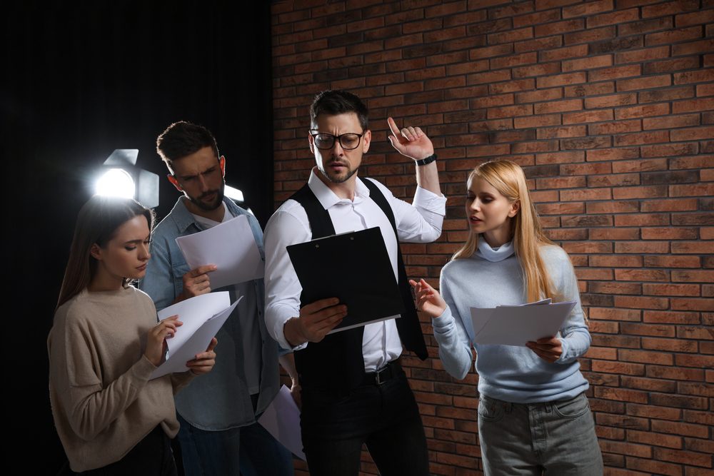Professional,Actors,Reading,Their,Scripts,During,Rehearsal,In,Theatre